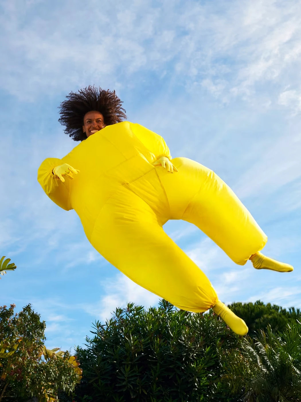 Campaign image: a figure in a yellow inflatable suit leaping through the sky